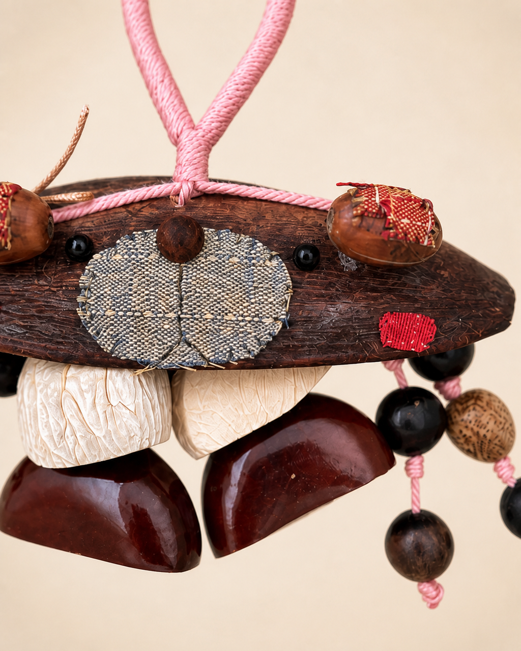 Detail of natural pod, textile, shell, bead and cord construction on a YUNOVA golden pod bear ornament