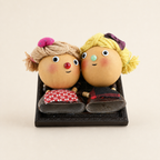 Blush and lime YUNOVA gourd doll duo framed refrigerator magnet on an ivory background