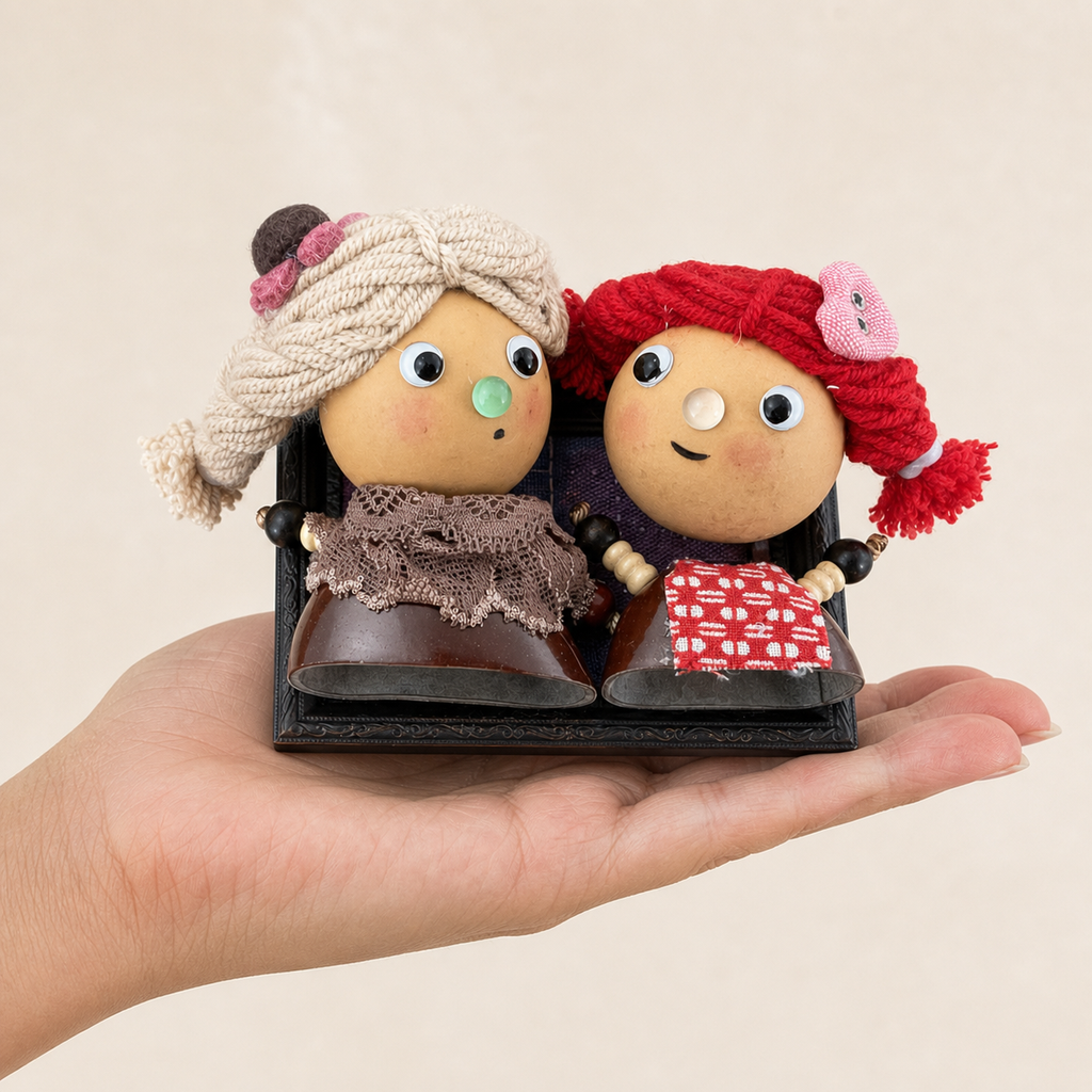 Adult hand holding an ivory and ruby YUNOVA gourd doll duo magnet to show scale