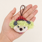 Adult hand holding a YUNOVA pod doll charm to show approximate scale