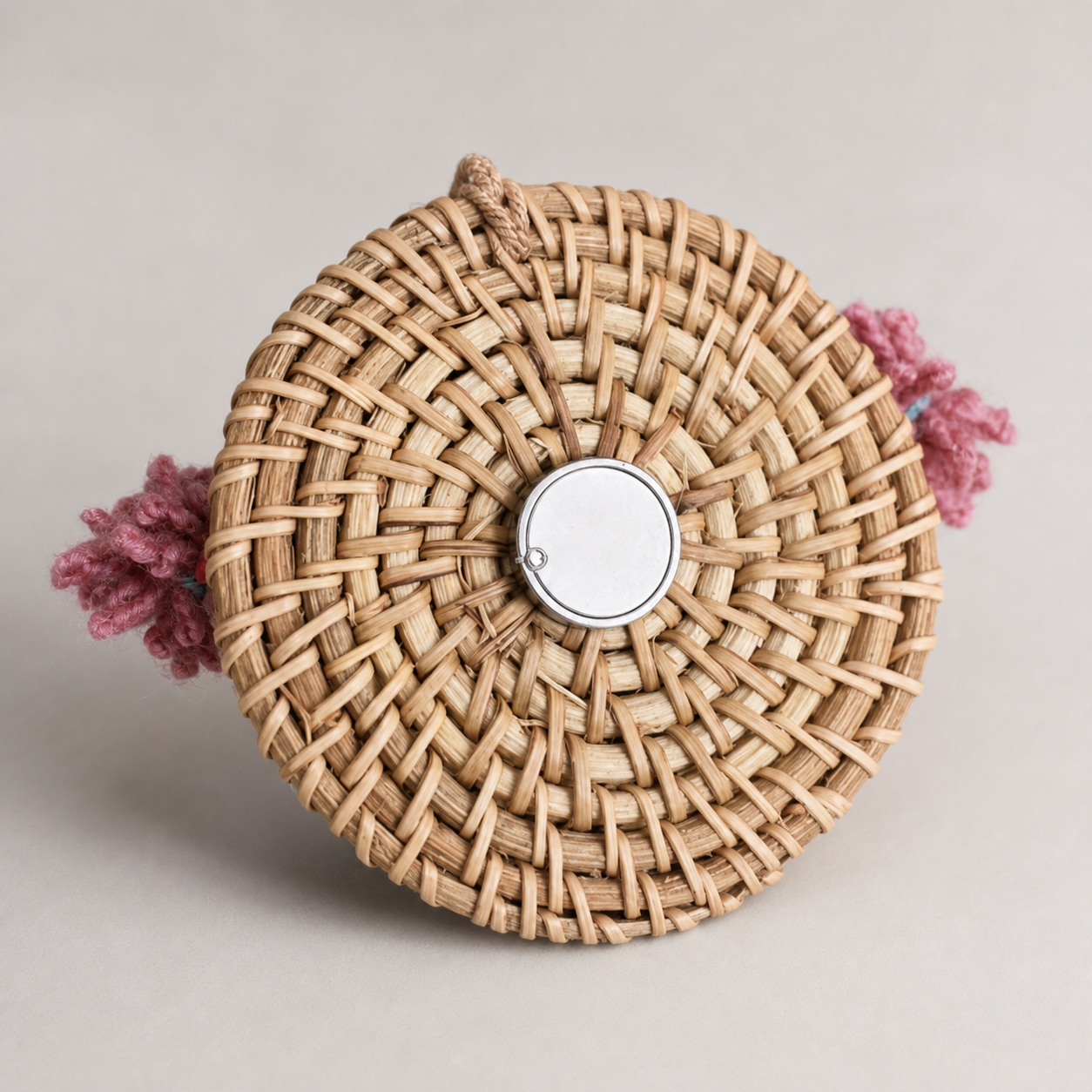 Close view of the woven bamboo back and round magnet on a YUNOVA pod doll charm